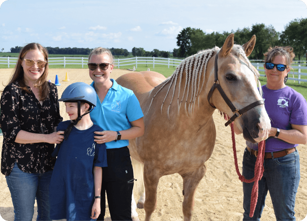 Smiling group with horse on sunny day